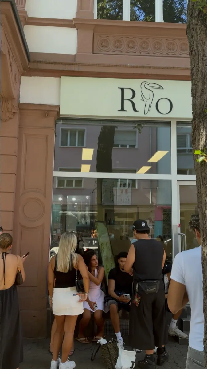 Gäste stehen vor RIO auf der Berger Straße Schlange, über der Tür das salbeigrüne Schild