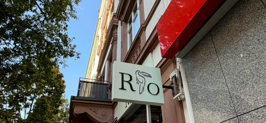 Die Fassade von RIO an der Berger Straße mit dem salbeigrünen Tukan-Schild